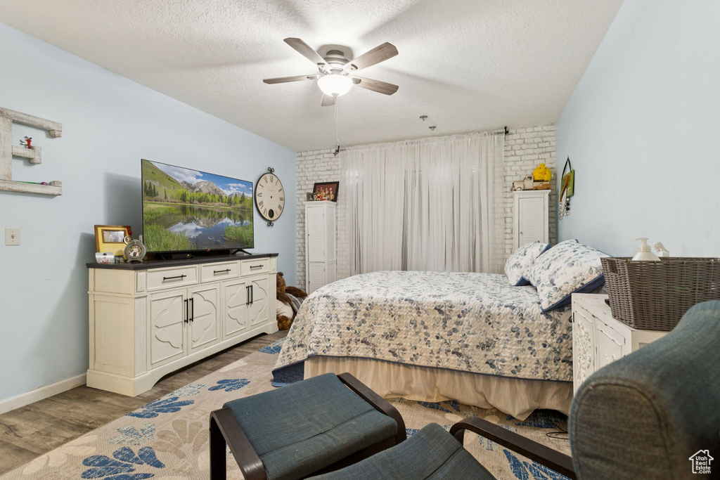 Bedroom featuring wood finished floors, a textured ceiling, and a ceiling fan