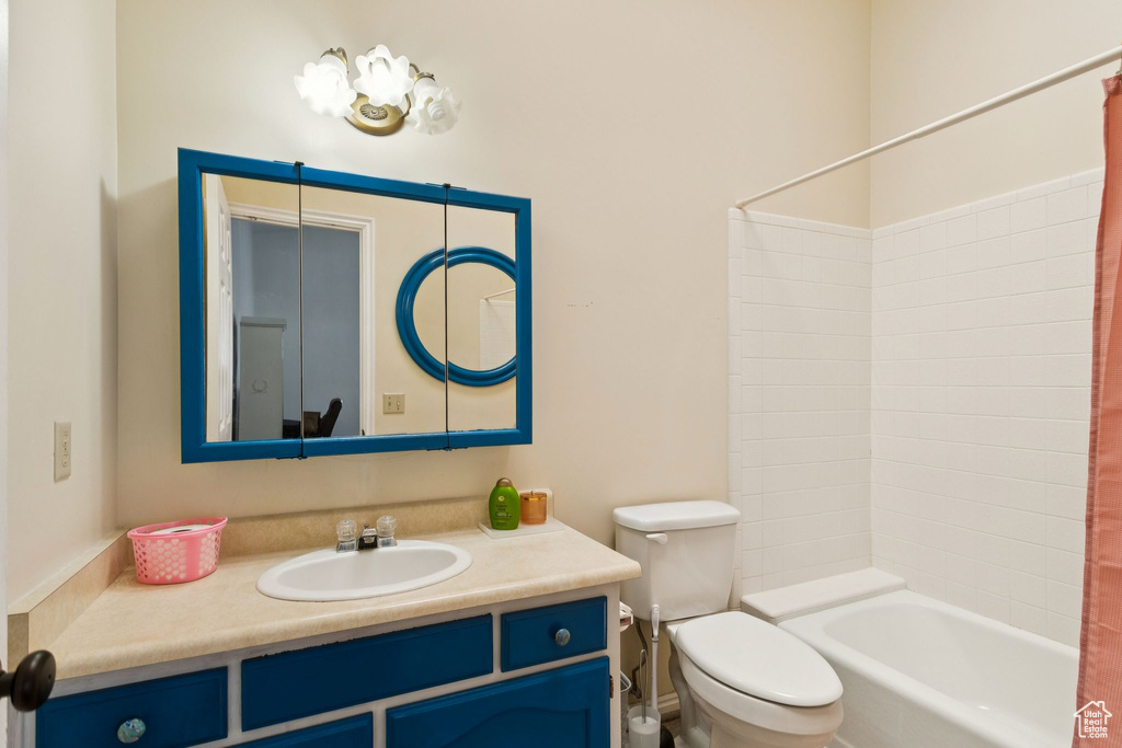 Bathroom featuring vanity and shower / bathtub combination with curtain