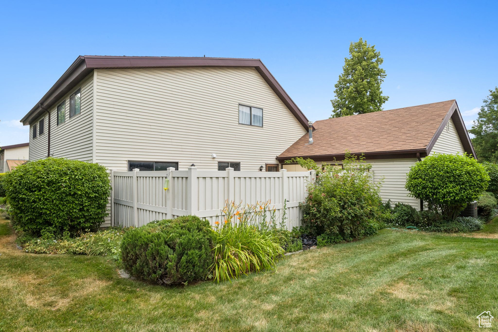 View of side of home with a shingled roof