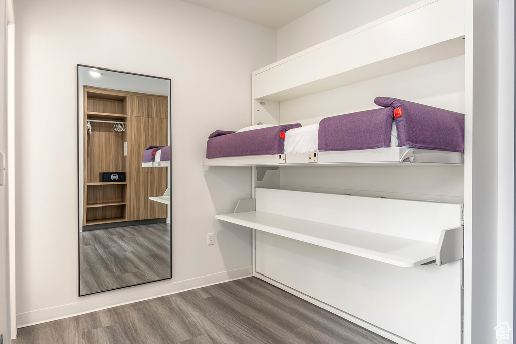Unfurnished bedroom with wood finished floors and baseboards