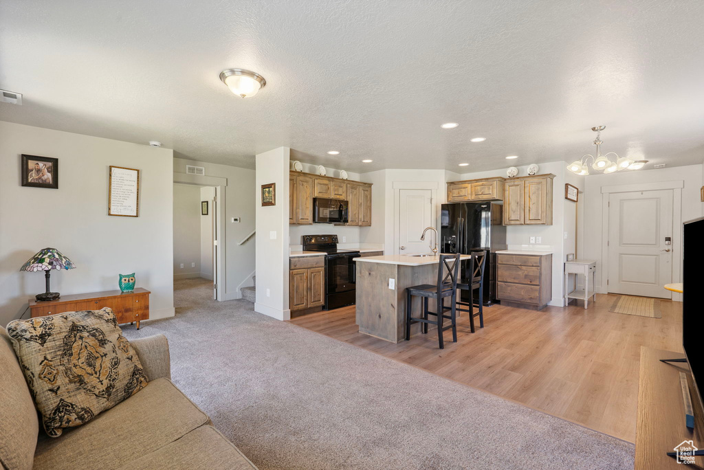 Living room with stairway, recessed lighting, a chandelier, and light wood-style floors