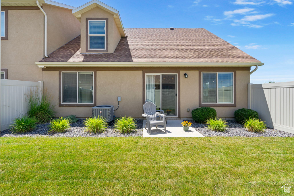 Rear view of house with stucco siding, a shingled roof, and a patio