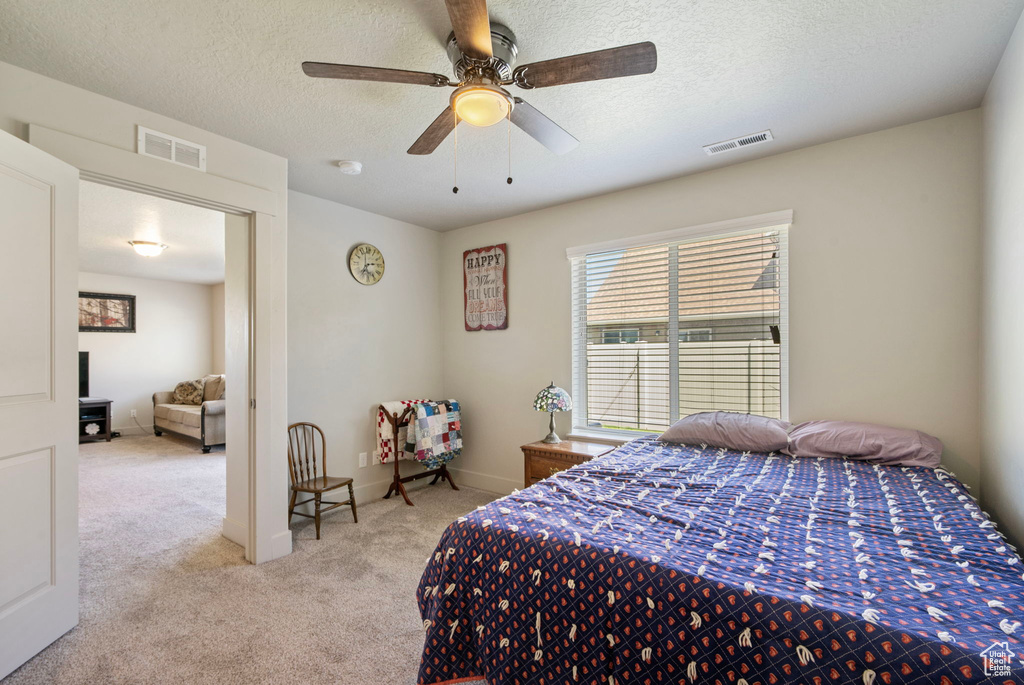 Bedroom featuring carpet, a textured ceiling, and ceiling fan