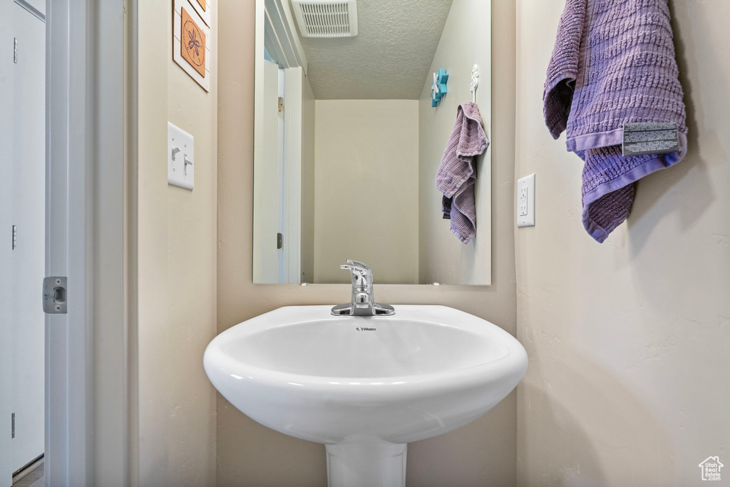 Bathroom featuring a sink and a textured ceiling
