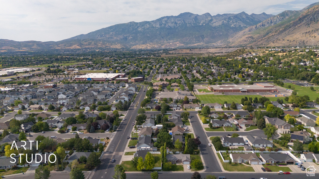 Aerial view of property's location featuring a mountainous background and nearby suburban area