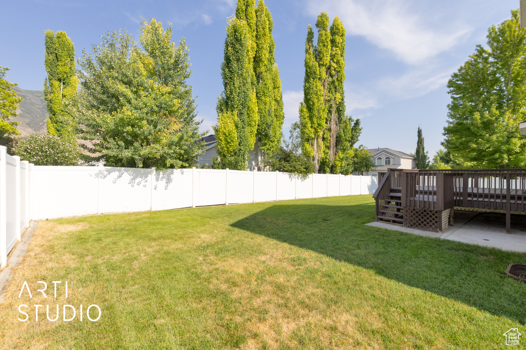 Fenced backyard with a wooden deck and stairway