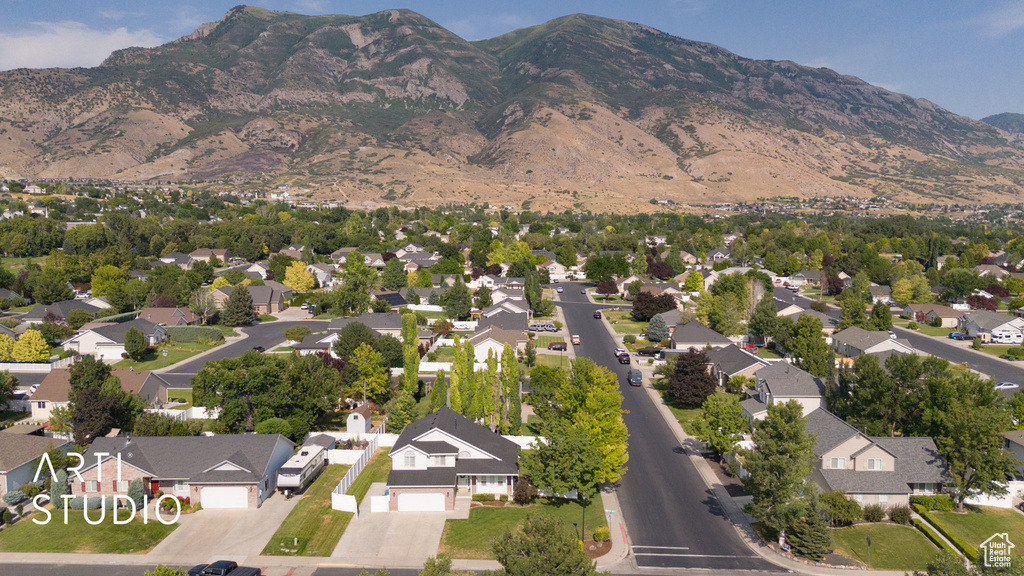 Aerial view of property and surrounding area with a mountain backdrop and nearby suburban area
