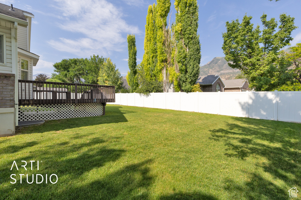 View of yard featuring a deck with mountain view