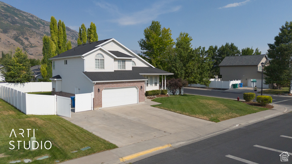 Traditional-style home featuring a garage, concrete driveway, brick siding, and a mountain view