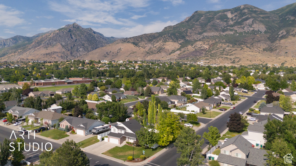 Aerial view of property's location with a mountain backdrop and nearby suburban area