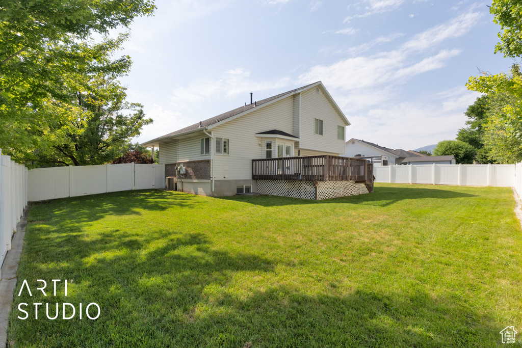 Rear view of property featuring a deck and a fenced backyard