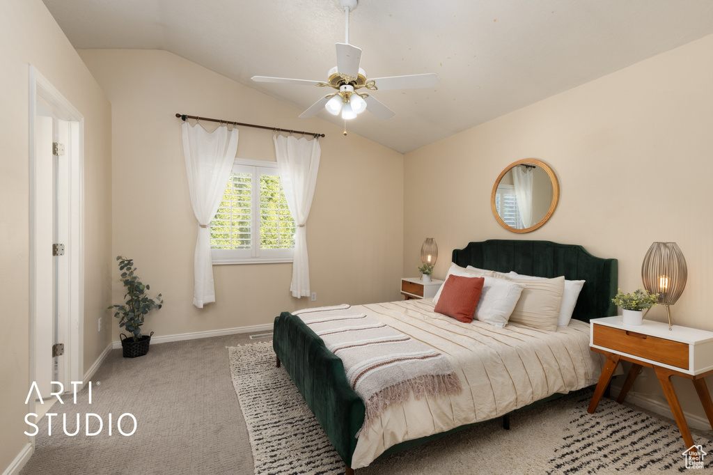 Carpeted bedroom featuring vaulted ceiling and ceiling fan