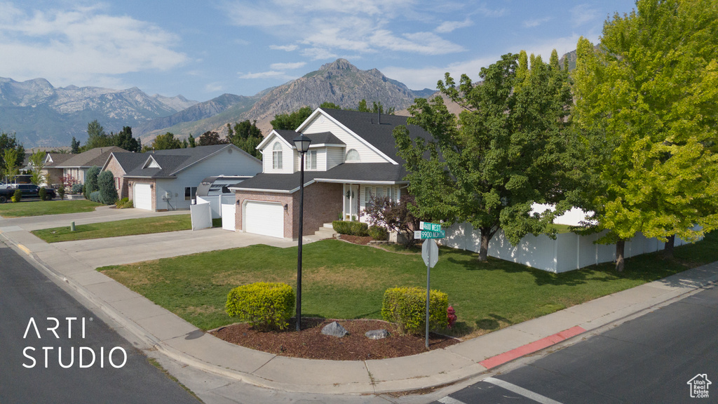 Traditional-style home with concrete driveway, an attached garage, brick siding, and a mountain view