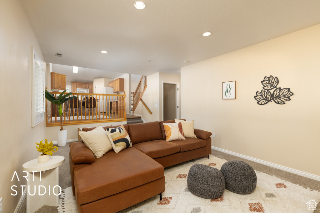Living room with stairway, light carpet, and recessed lighting