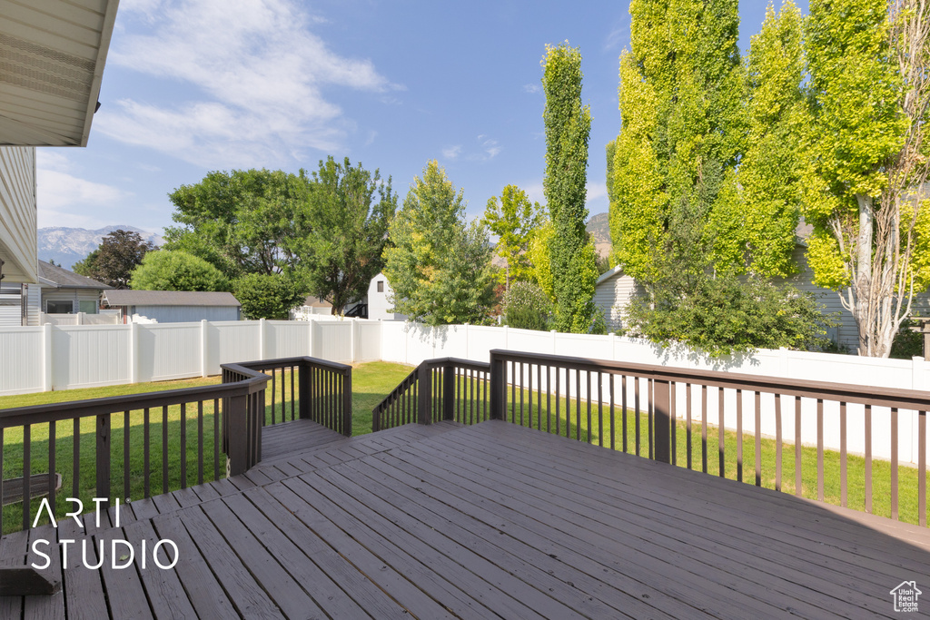 Wooden terrace featuring a fenced backyard and a mountain view