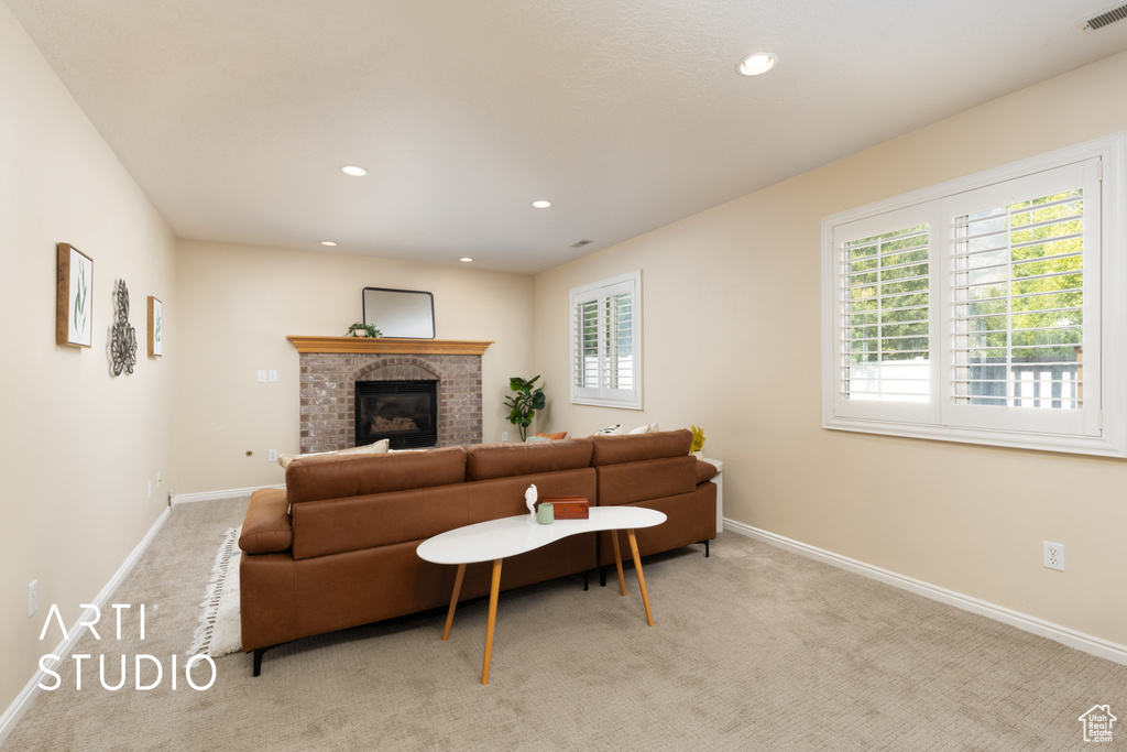 Living area with plenty of natural light, carpet, recessed lighting, and a fireplace