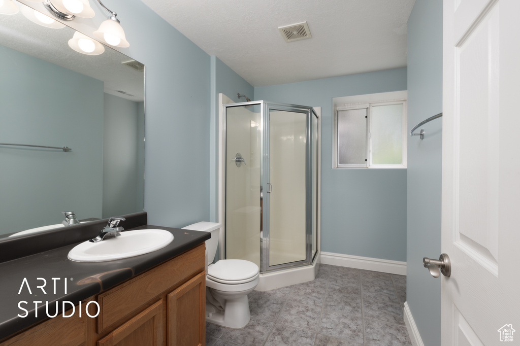 Full bathroom with a shower stall, vanity, and tile patterned floors