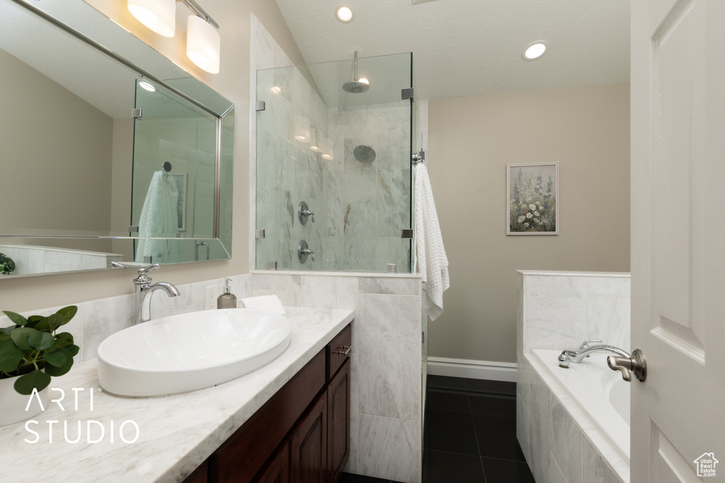 Full bathroom featuring a stall shower, a bath, vanity, tile patterned floors, and recessed lighting