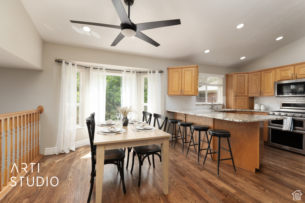 Dining space with plenty of natural light, recessed lighting, ceiling fan, dark wood-type flooring, and vaulted ceiling