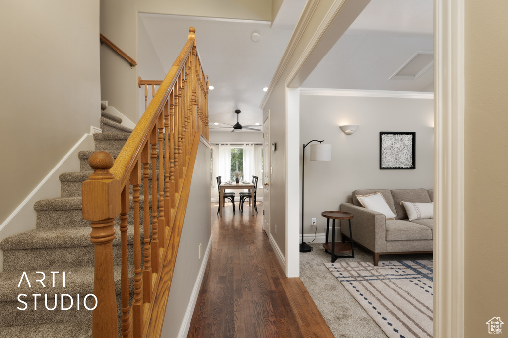 Corridor featuring wood finished floors, crown molding, stairway, and recessed lighting