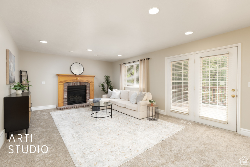 Living room featuring carpet flooring, recessed lighting, and a brick fireplace