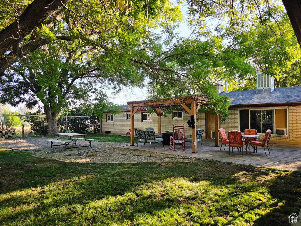 Rear view of property featuring a pergola and a patio