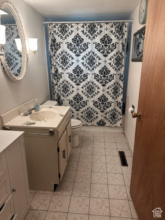 Full bath with vanity, curtained shower, and a textured wall