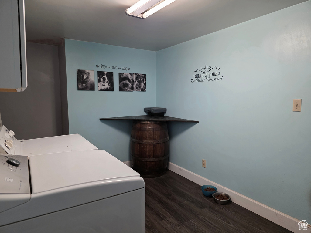 Washroom with independent washer and dryer, dark wood-style flooring, and cabinet space