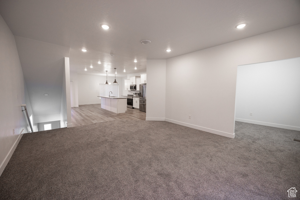 Unfurnished living room featuring recessed lighting and light carpet