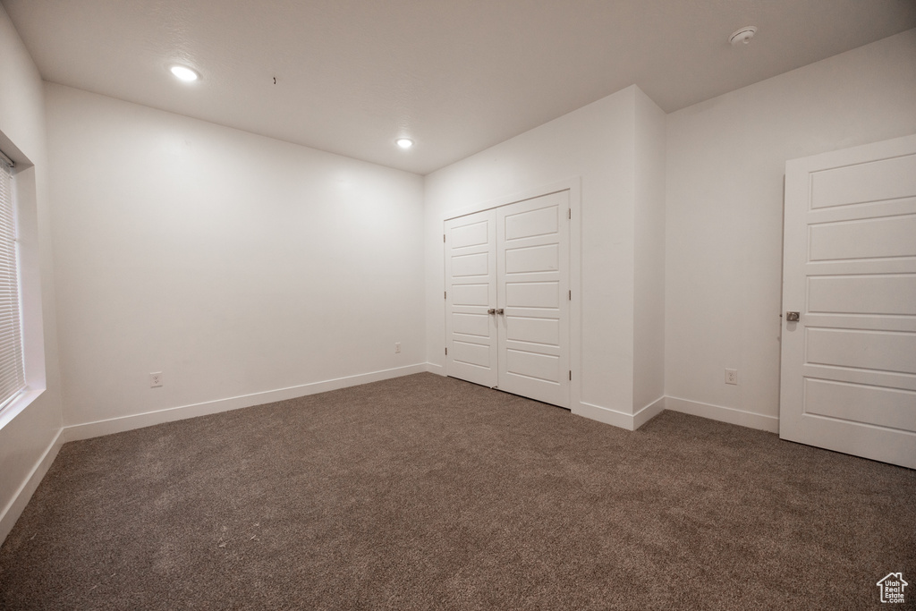 Unfurnished bedroom featuring carpet floors, recessed lighting, and a closet
