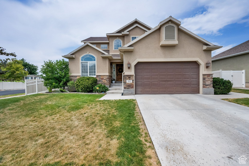 View of front of home featuring stone siding, stucco siding, a garage, and driveway