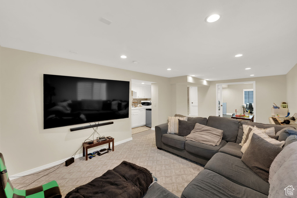 Living area with light colored carpet and recessed lighting