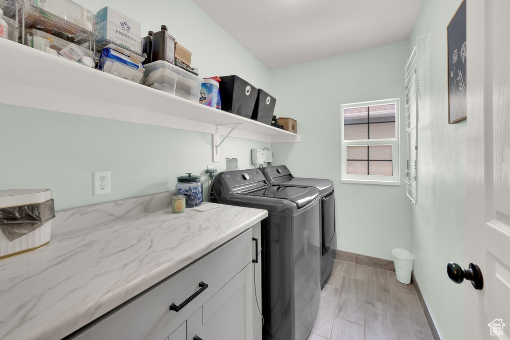 Washroom featuring washer and dryer and cabinet space