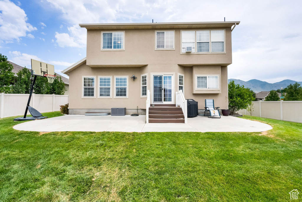 Back of house featuring stucco siding, a patio area, and a fenced backyard
