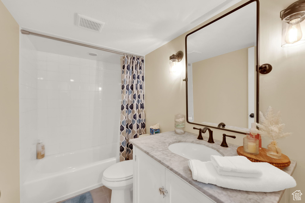 Full bathroom featuring vanity, shower / bathtub combination with curtain, and tile patterned flooring