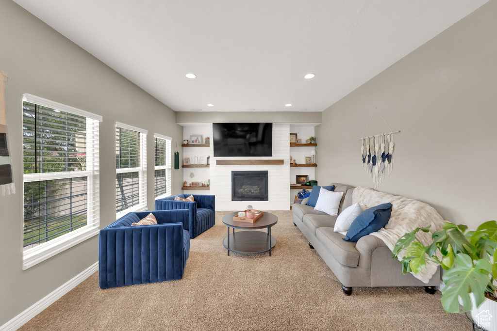 Living room with carpet flooring, recessed lighting, and a large fireplace