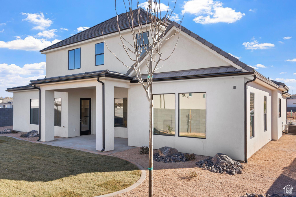 Back of property with a patio area, stucco siding, and a lawn