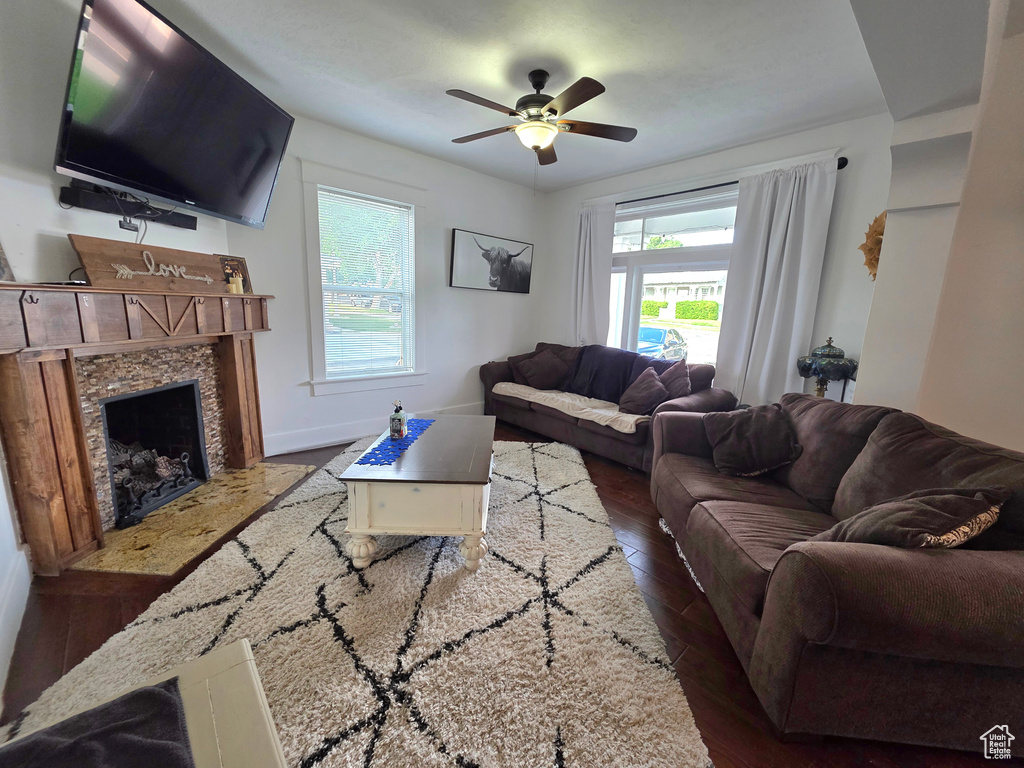 Living area featuring hardwood / wood-style flooring, a premium fireplace, and a ceiling fan