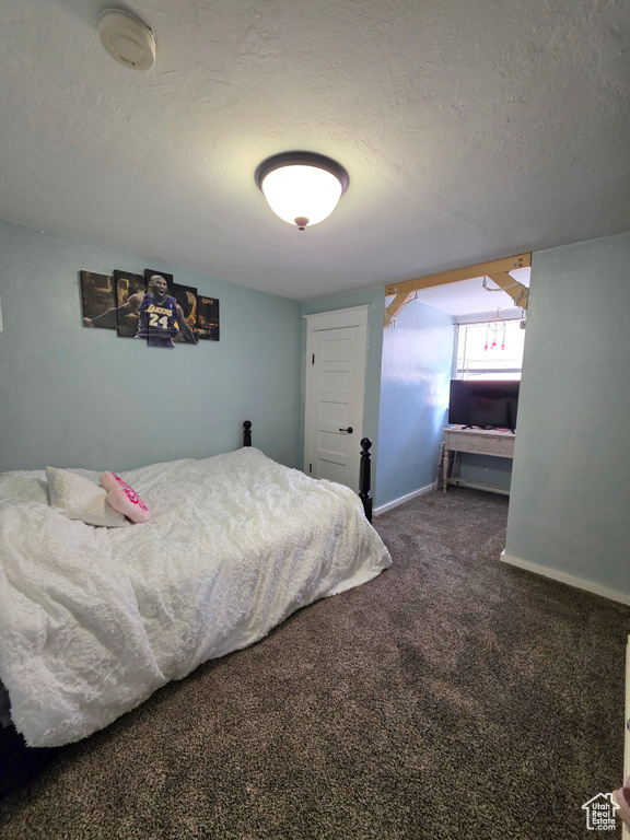 Bedroom with a textured ceiling and carpet floors