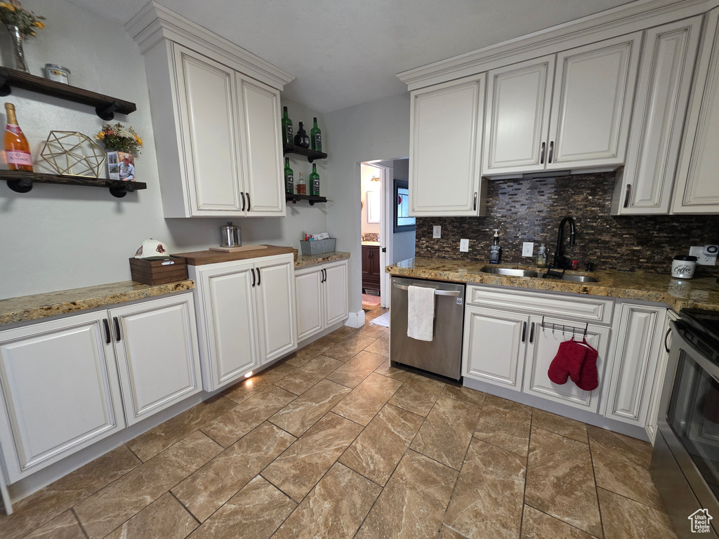 Kitchen with open shelves, appliances with stainless steel finishes, light stone finish floors, decorative backsplash, and white cabinets