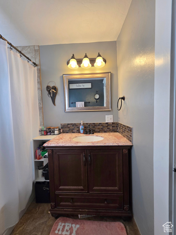 Full bathroom with vanity, backsplash, and shower / bath combo