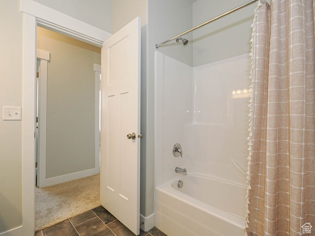 Full bathroom featuring shower / bath combo with shower curtain and tile patterned floors