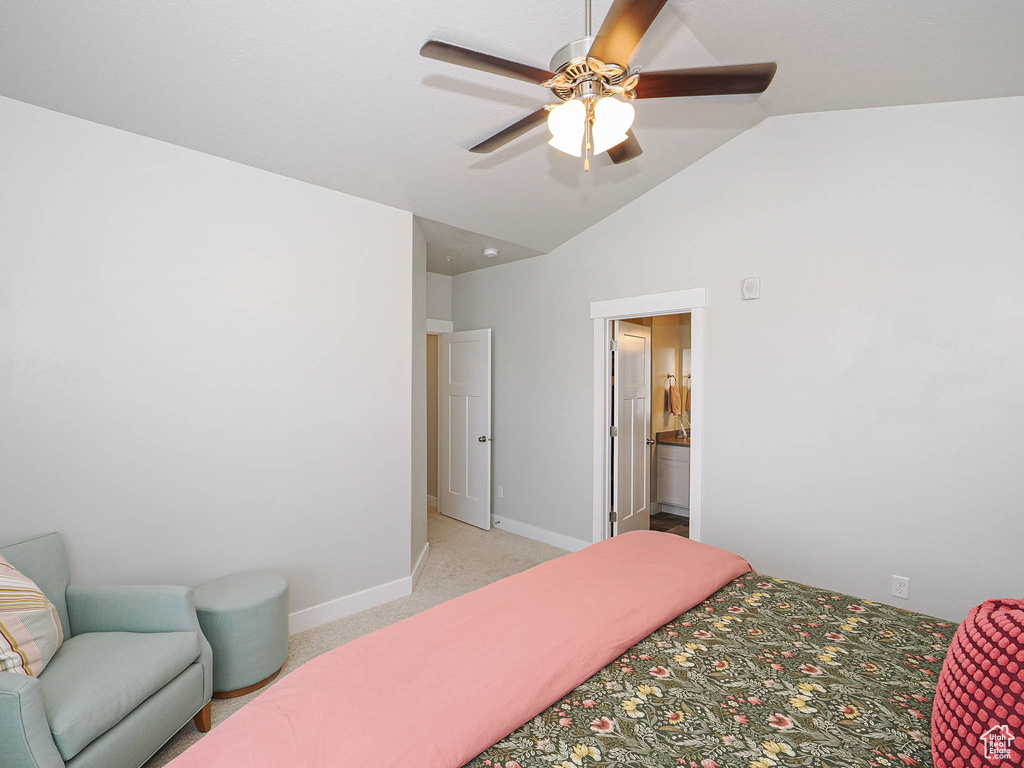 Bedroom featuring light carpet, lofted ceiling, ceiling fan, and ensuite bath