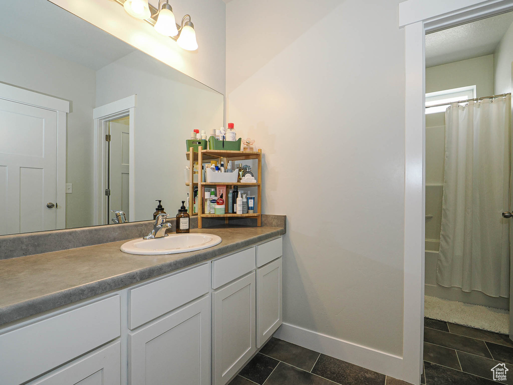 Full bathroom with vanity, tile patterned floors, and shower / tub combo with curtain