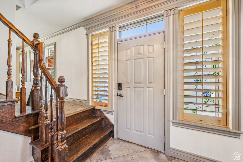 Foyer entrance with stairs and light tile patterned flooring