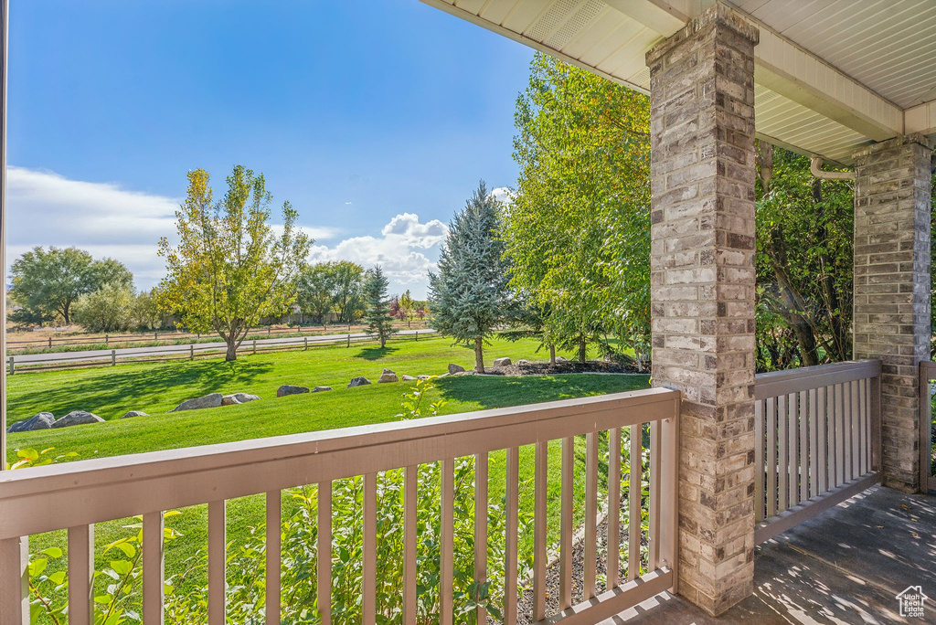 Wooden porch featuring a yard