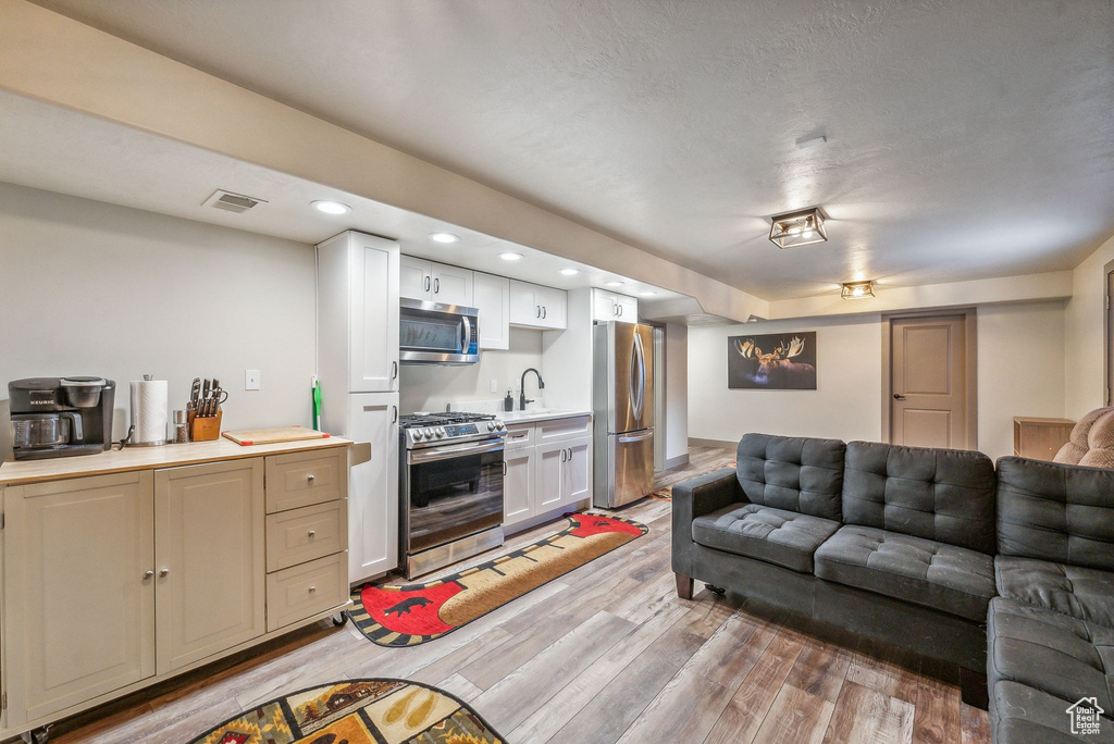 Living area featuring light wood finished floors and recessed lighting