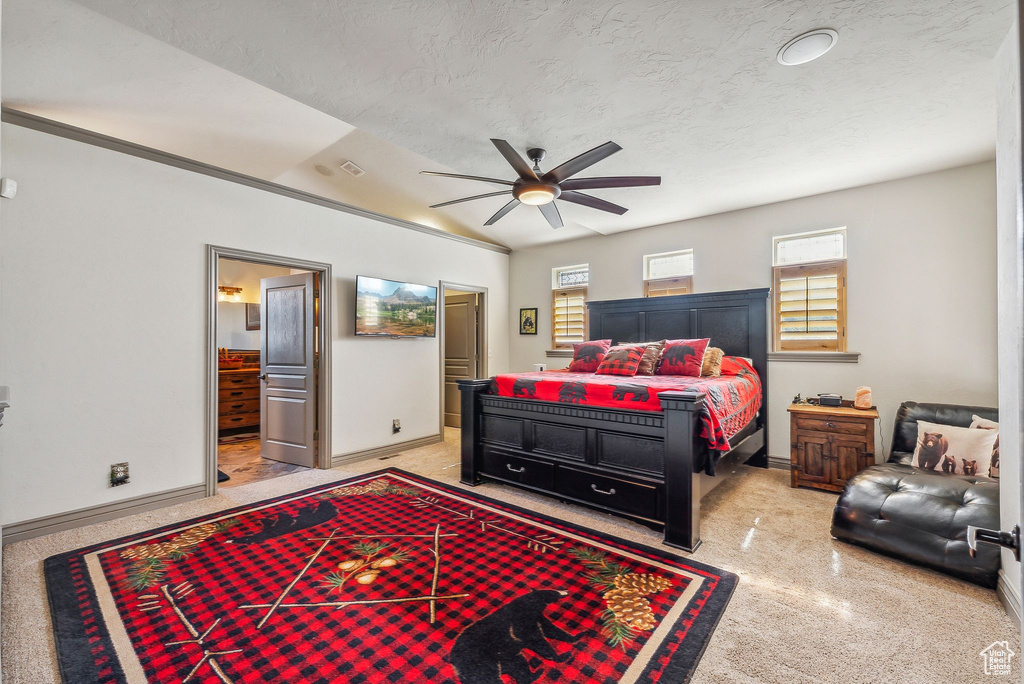 Bedroom featuring ensuite bath, a textured ceiling, and a ceiling fan