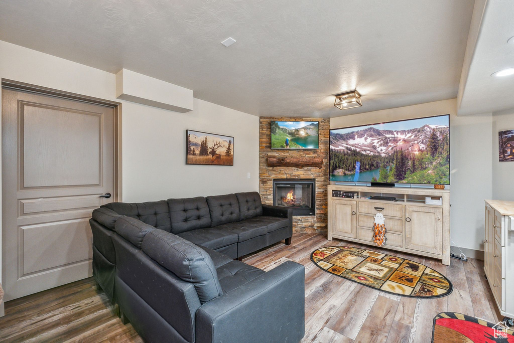 Living area featuring a stone fireplace and wood finished floors