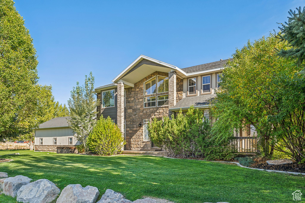 View of front of property featuring a front yard and stone siding